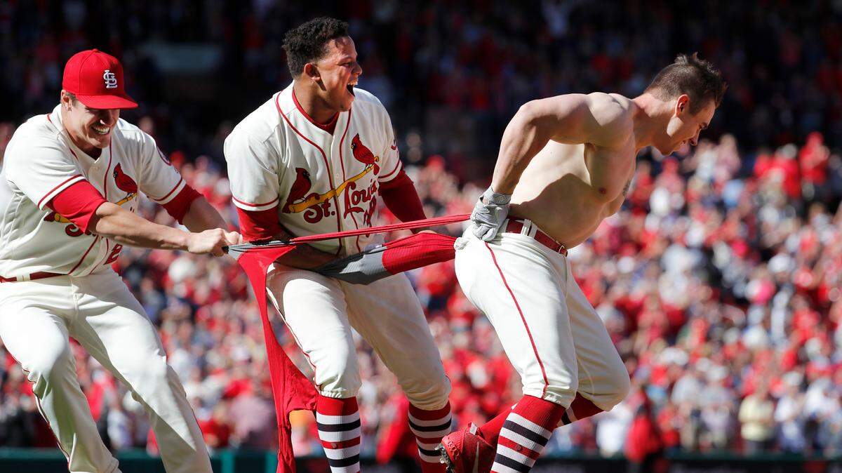 St. Louis Cardinals’ Tyler O’Neill has his jersey ripped off by teammates Yairo Munoz, center, and Patrick Wisdom, left, after O’Neill hit a walk-off home run to defeat the San Francisco Giants 5-4 in the 10th inning of a baseball game Saturday, Sept. 22, 2018, in St. Louis. (AP Photo/Jeff Roberson)