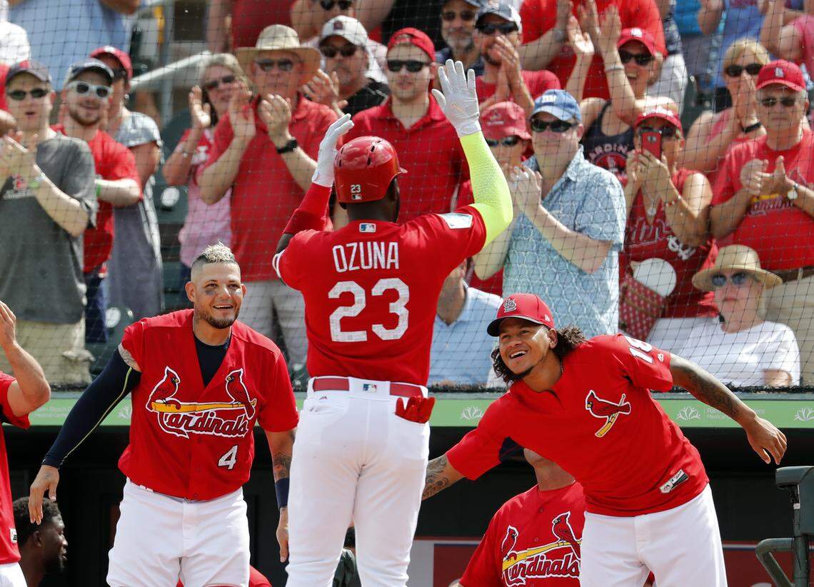 Marcell Ozuna is congratulated by teammates Yadier Molina and Carlos Martinez after hitting a solo home run, his first as a Cardinal, during the second inning of a spring training game March 1 against the Minnesota Twins in Jupiter, Fla.