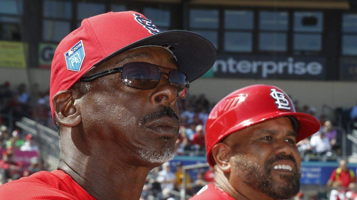 Cardinals coaches Willie McGee and Jose Oquendo watch a spring training game from the dugout at Roger Dean Stadium in Jupiter, Florida.