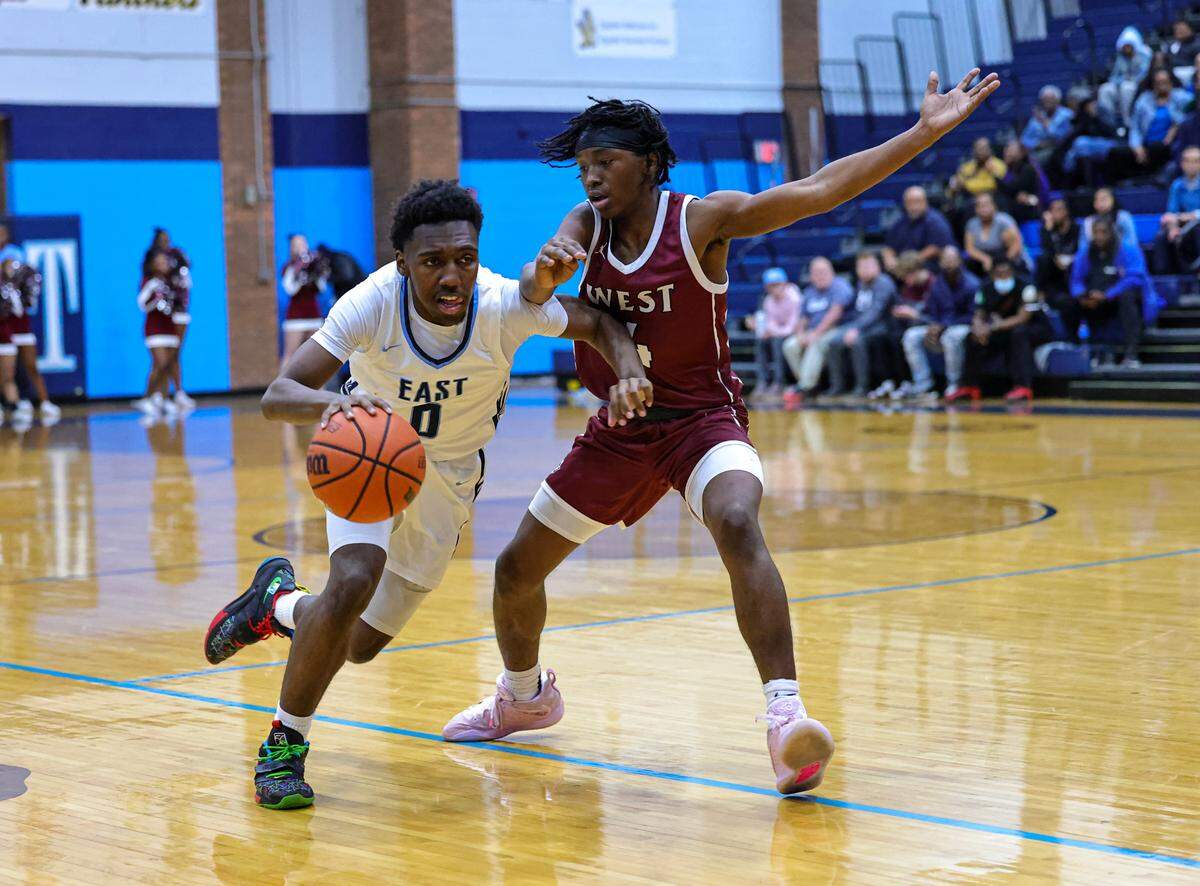 Belleville East’s T’Jae Montgomery drives against Belleville West’s Brandon Scott during Friday night’s Southwestern Conference game. The Lancers ultimately posted a 66-57 victory.