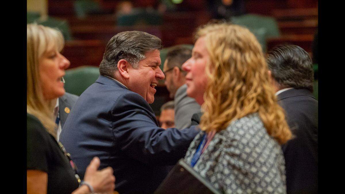 PRITZKER: Gov. JB Pritzker talks with members of the Illinois House prior to a vote on his initiative to reform the state’s insurance industry. (Capitol News Illinois photo by Jerry Nowicki)