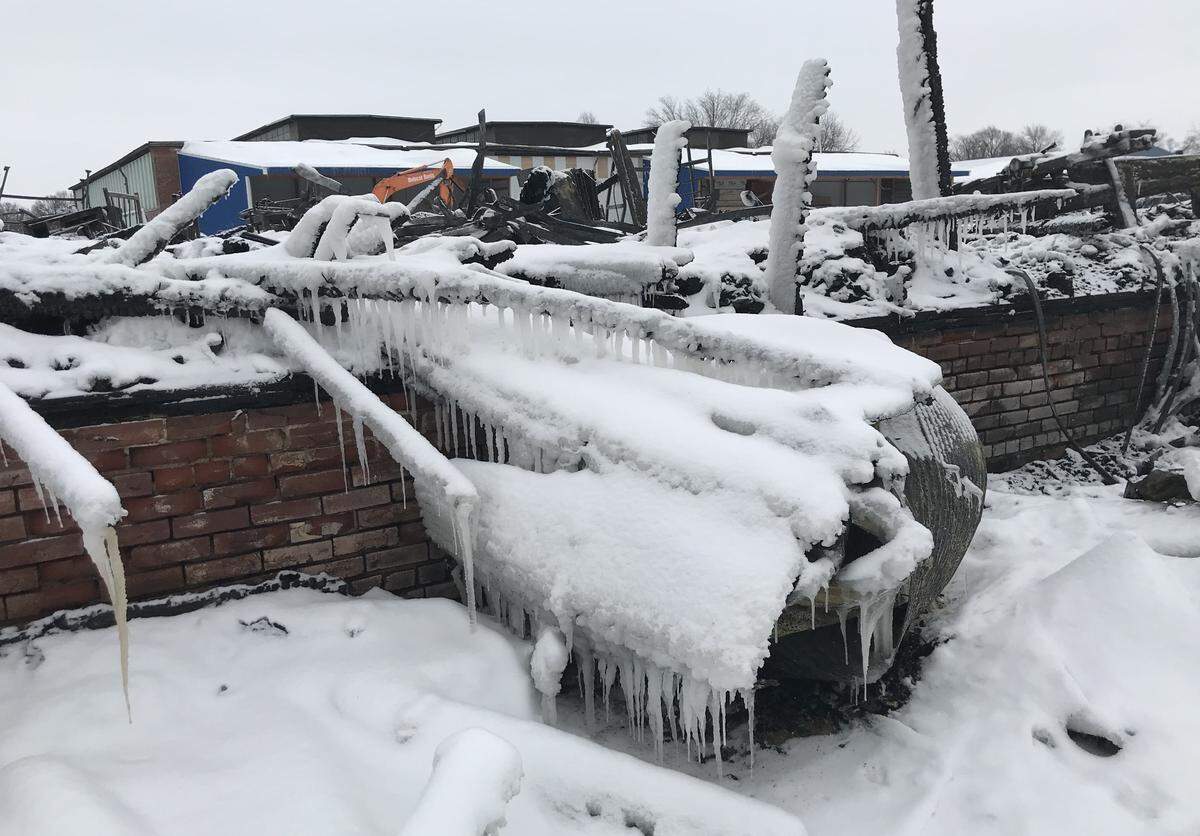 Snow covers a mangled mess of burned equipment and millwork products in an outbuilding of R.P. Lumber Co. in Edwardsville after a fire on Monday. The cause is being investigated.