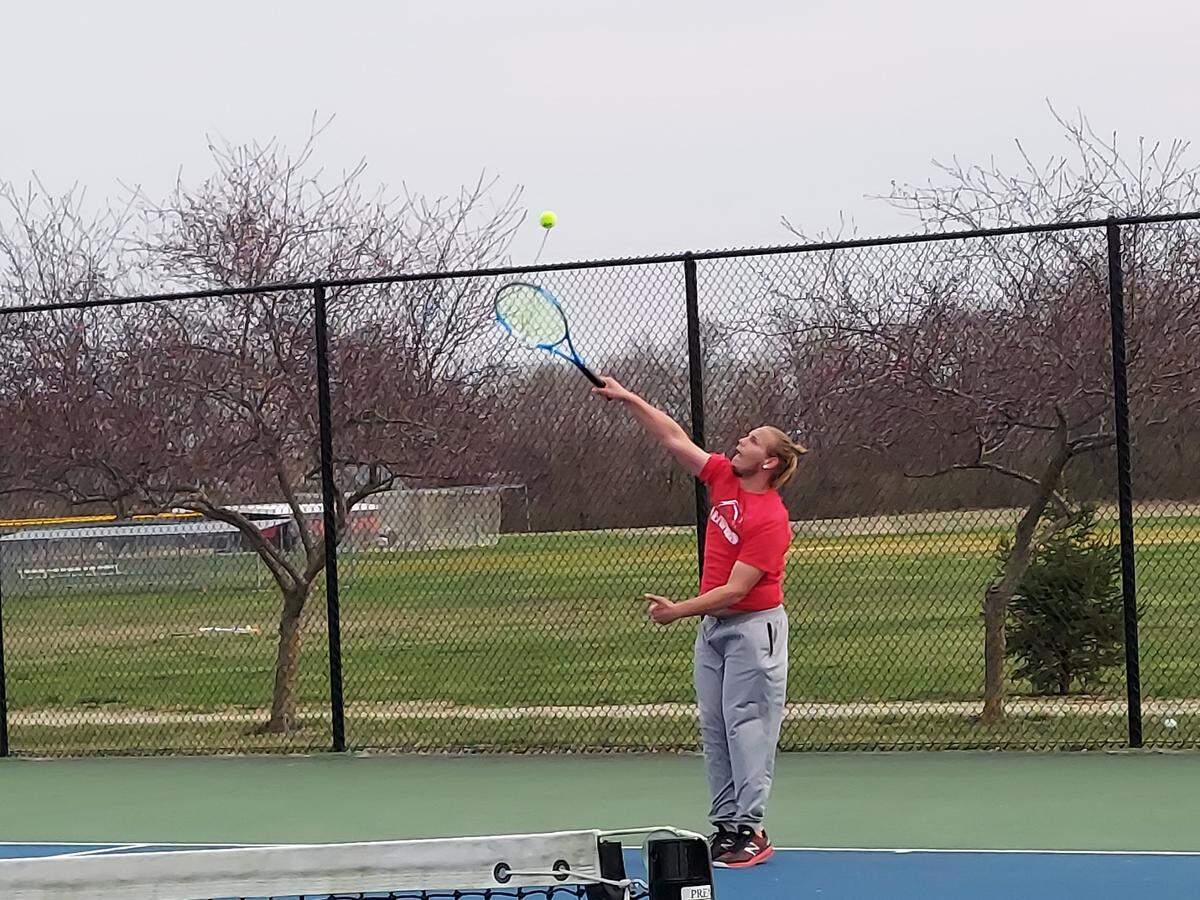 Highland senior Tyler Kutz finishes a serve during his No. 1 singles match against Belleville West this spring. Kutz, Alex Roach and&nbsp;Isaac Pasley all advanced to the IHSA Class 1A state tournament for the Bulldogs.