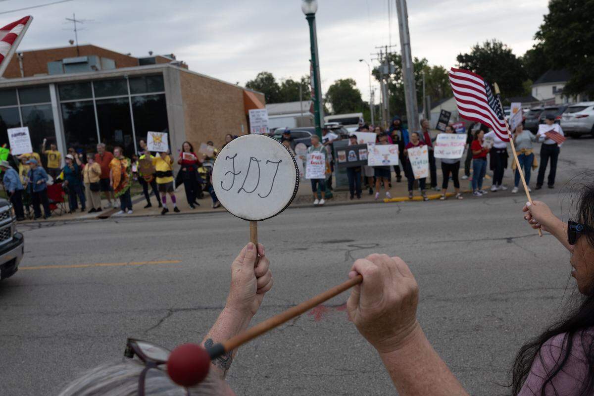 A protester bangs a drum displaying the letters “FDT,” a common phrase used among progressive demonstrators, during a No Kings protest along O’Fallon’s Main Street on Saturday.