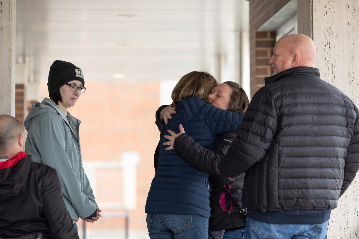 Jenny Hosler, second from right, hugs family members outside the Madison County Criminal Justice Center on Friday, the last day of testimony in the murder trial of her brother, Neil Howard.