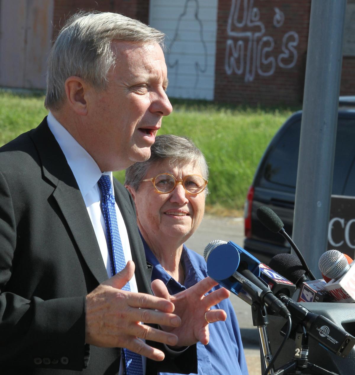 Sr. Julia Huiskamp DC listens as US Senator Dick Durbin addresses members of the media during a visit to the John DeShields housing complex in East St. Louis in 2011. Next to the housing complex is the boarded up former Lincoln High School.