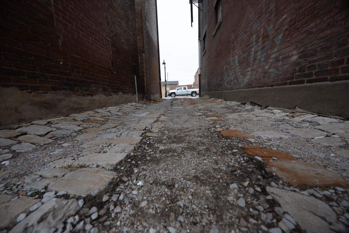 The alleyway providing access between the rear and front of the home features historic cobblestones.
