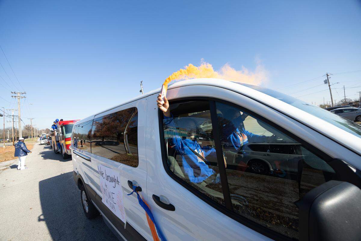 A van marked with the sign “We brought the SMOKE all 2024” moves along with the Flyers’ victory parade, all the while holding an orange smoke canister out of the window.
