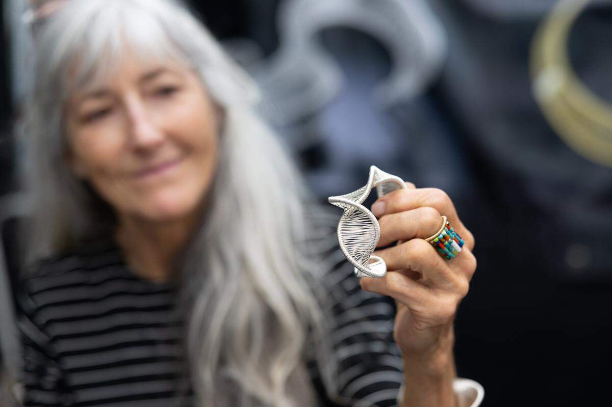 Tana Acton holds up one of her favorite pieces of jewelry during the first day of Belleville’s famous Art on the Square on May 17, 2024.