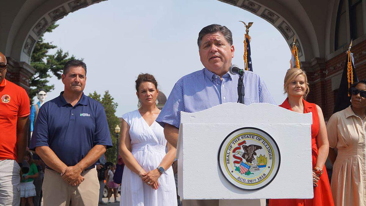 Gov. JB Pritzker speaks to reporters outside the Illinois State Fairgrounds after cutting a ribbon to officially open the fair on Thursday.