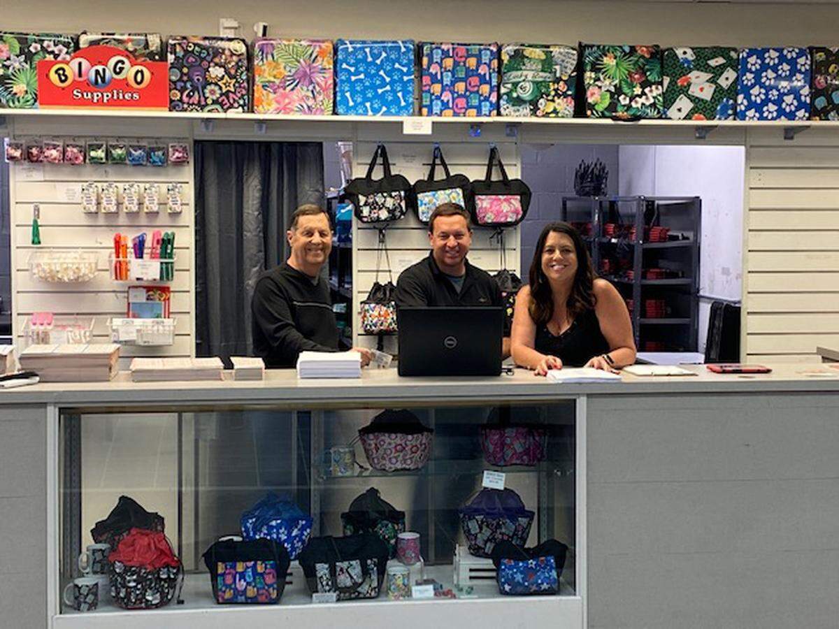 Dennis Tribout Sr., Denny Tribout and Sherri Glaenzer at the concession counter with bingo bags and other supplies at BelleVegas Bingo Hall.