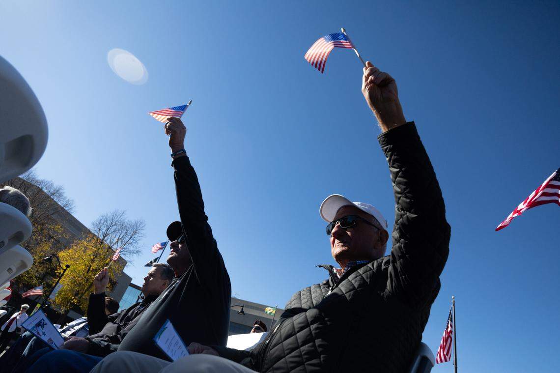 Veterans wave their flags during a performance of “America the Beautiful” during Belleville’s 26th annual Veterans Day ceremony on Nov. 11, 2024.