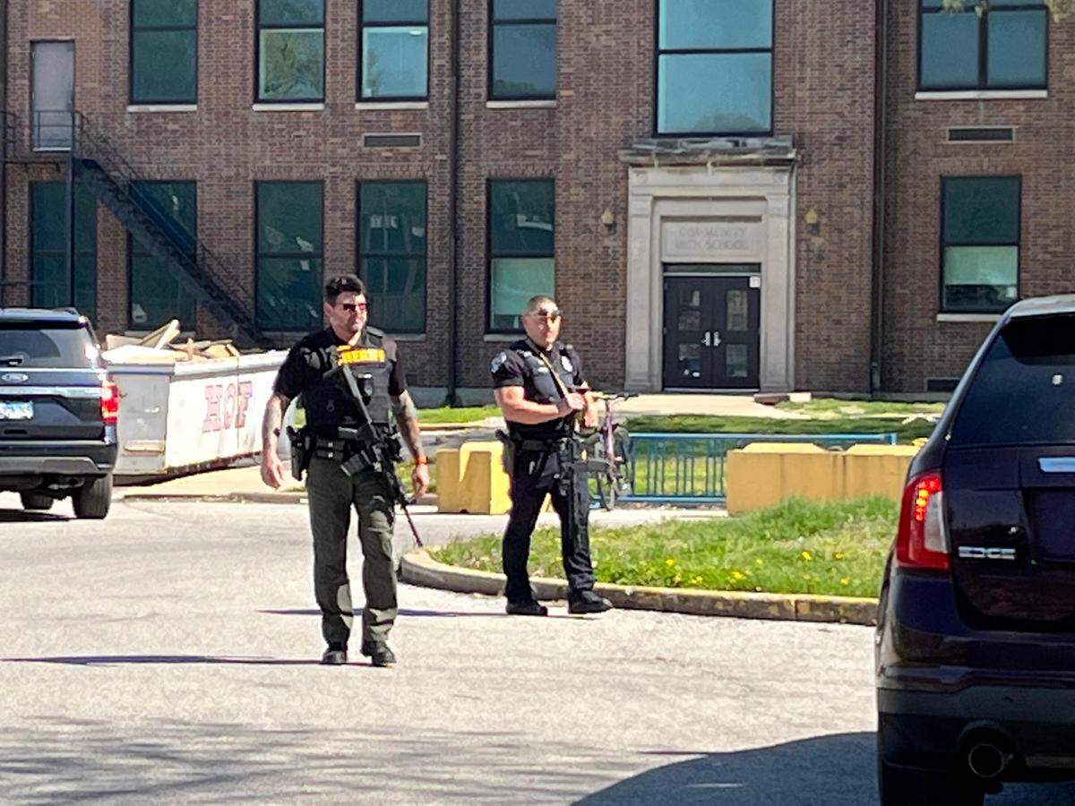 Police officers speak to parents of Granite City students from their vehicle Wednesday.