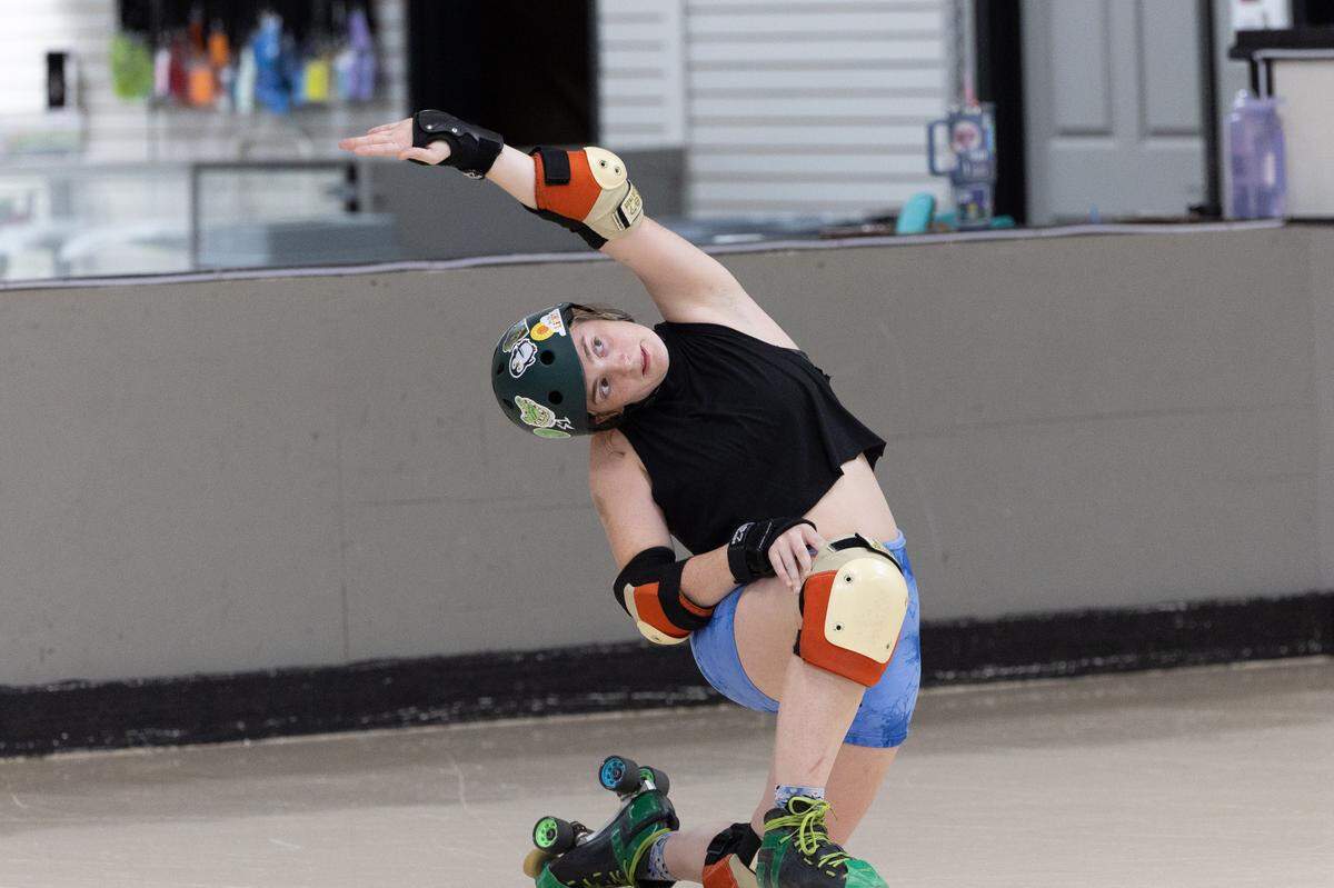 Cailyn Tegel, who goes by the derby name Swamp Smasher, leads a stretching exercise at Confluence Crush’s training rink in Troy.