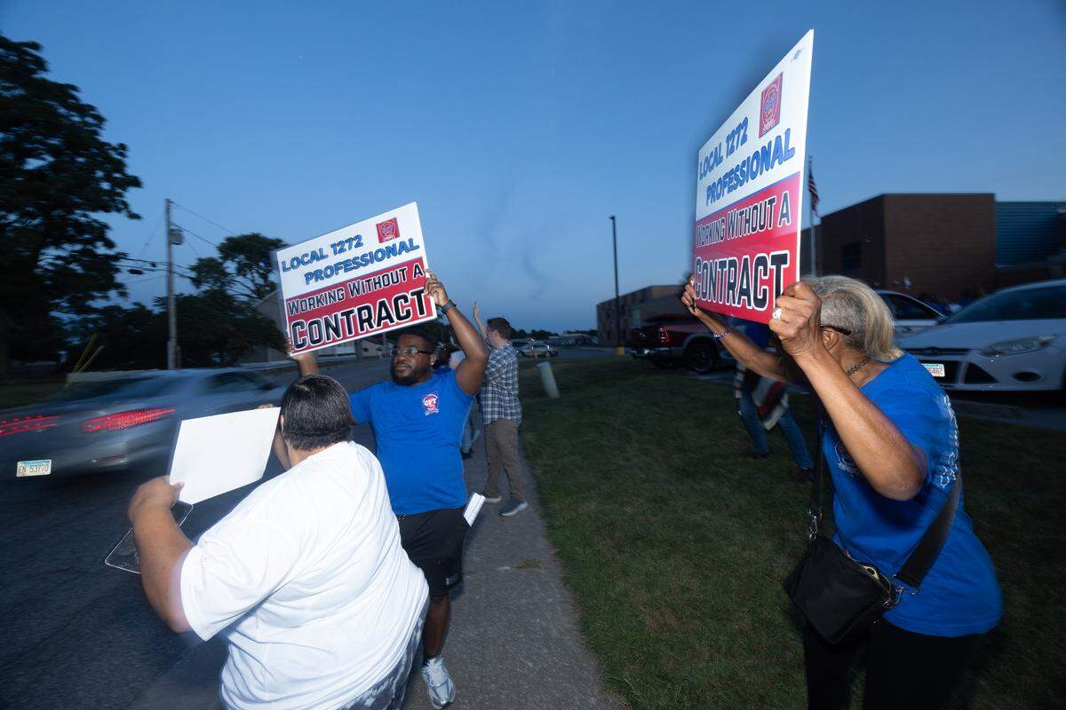 Members of Cahokia Federation of Teachers Local 1272 hold up signs displaying their grievances with Cahokia school district. Unionized personnel have gone weeks without a contract, despite the start of the school year.