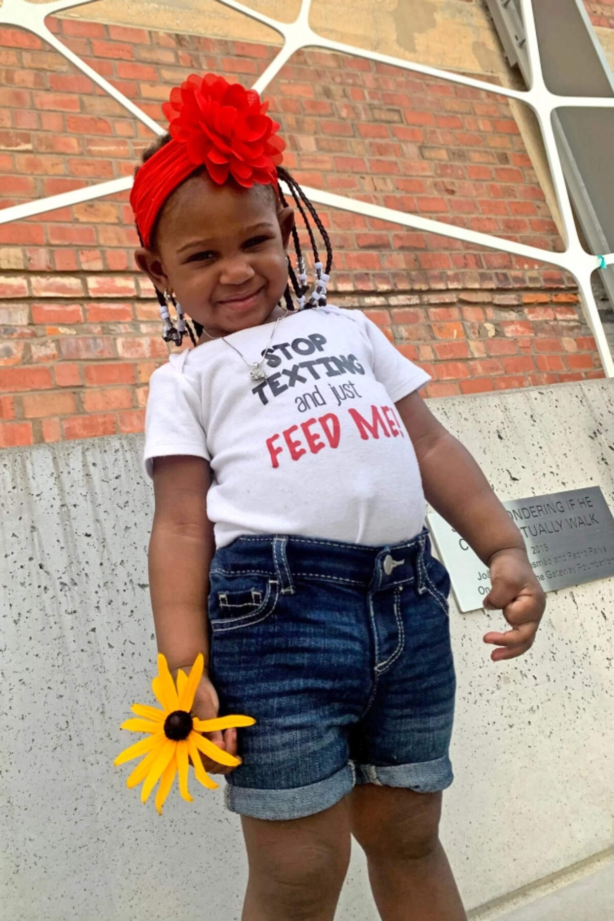 Calyia Stringer poses for a photo with a yellow flower in her hand after spending the day with her godmother, Jatoria Foster. Calyia was killed a month after her 3rd birthday.