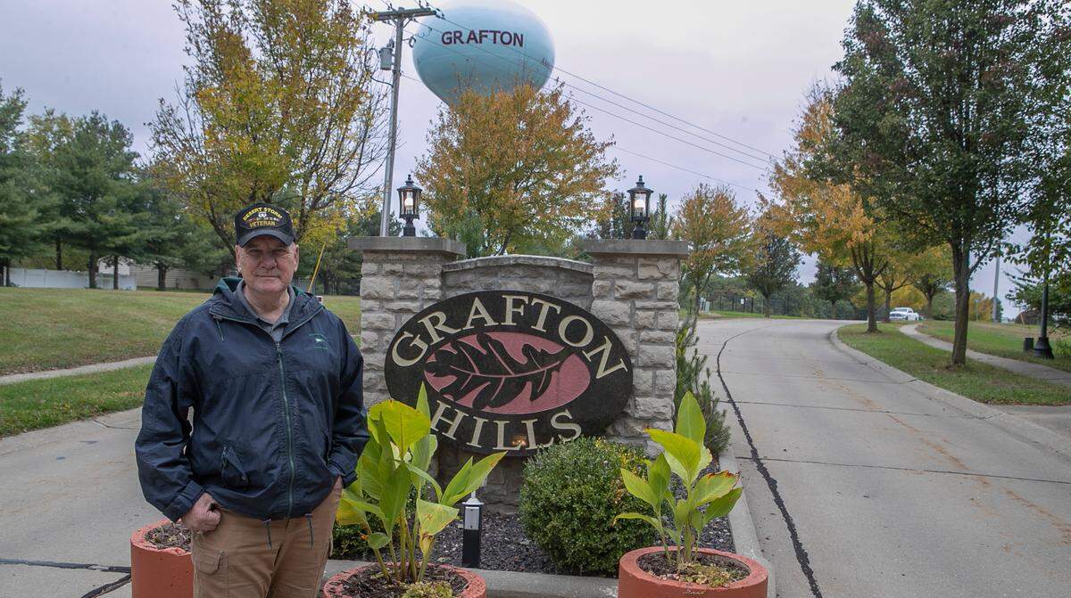 Mayor Michael Morrow stands in front of the sign for Grafton Hills in November. The subdivision was established on the bluff after the Great Flood of 1993 kept lower Grafton underwater for seven months.