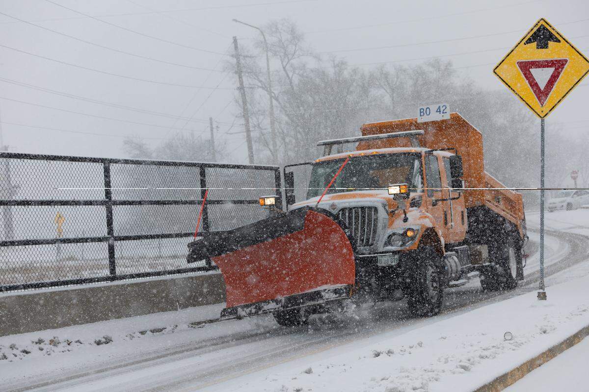 A snowplow makes its way through East St. Louis, near the entrance ramp to Interstate 64 on Monday.