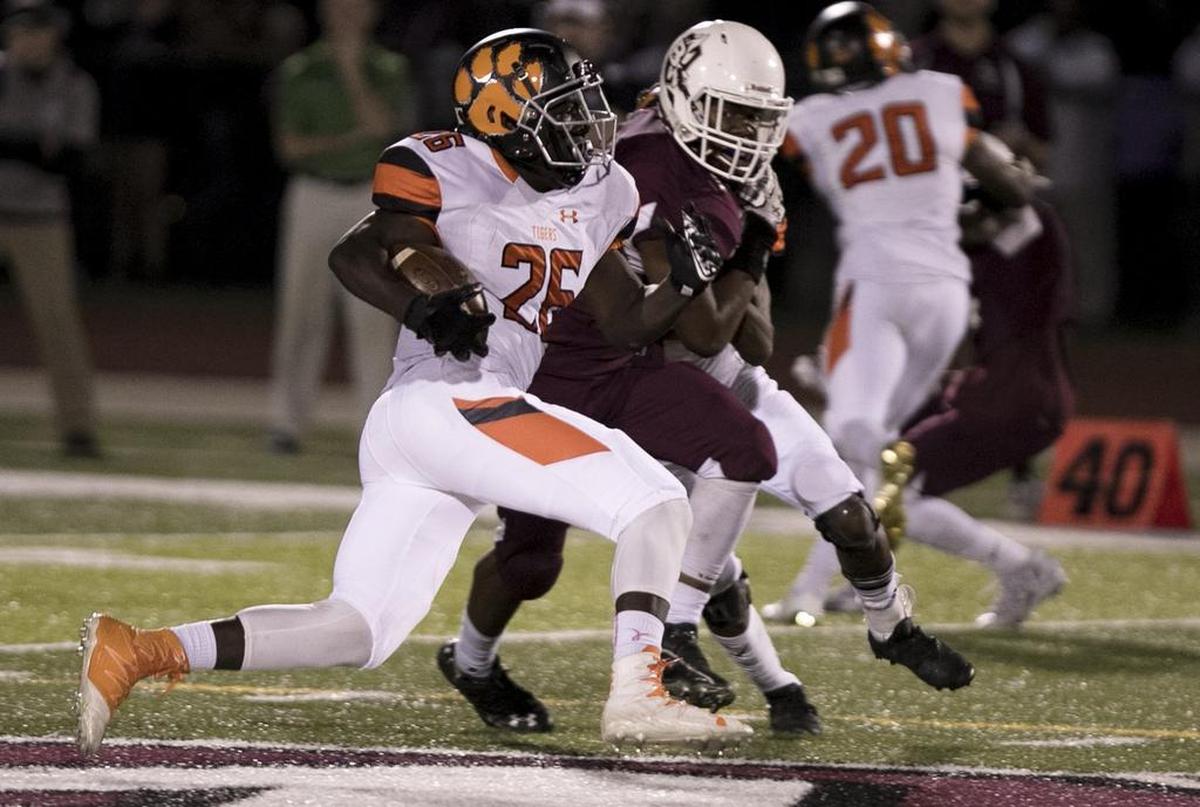 Edwardsville’s Justin Johnson carries the ball against Belleville West.