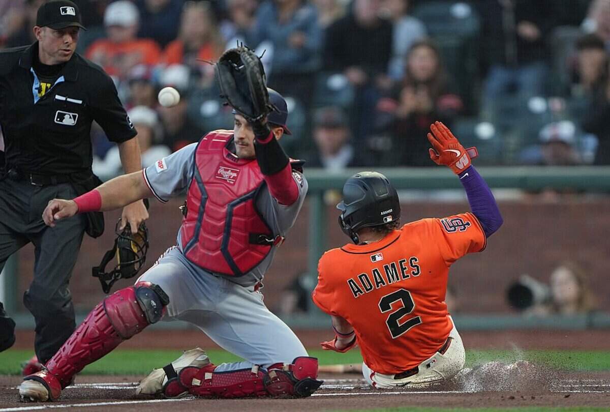 SAN FRANCISCO, CALIFORNIA - AUGUST 08: Willy Adames #2 of the San Francisco Giants scores ahead of the throw to catcher Drew Millas #81 of the Washington Nationals in the bottom of the first inning at Oracle Park on August 08, 2025 in San Francisco, California. (Photo by Thearon W. Henderson/Getty Images)