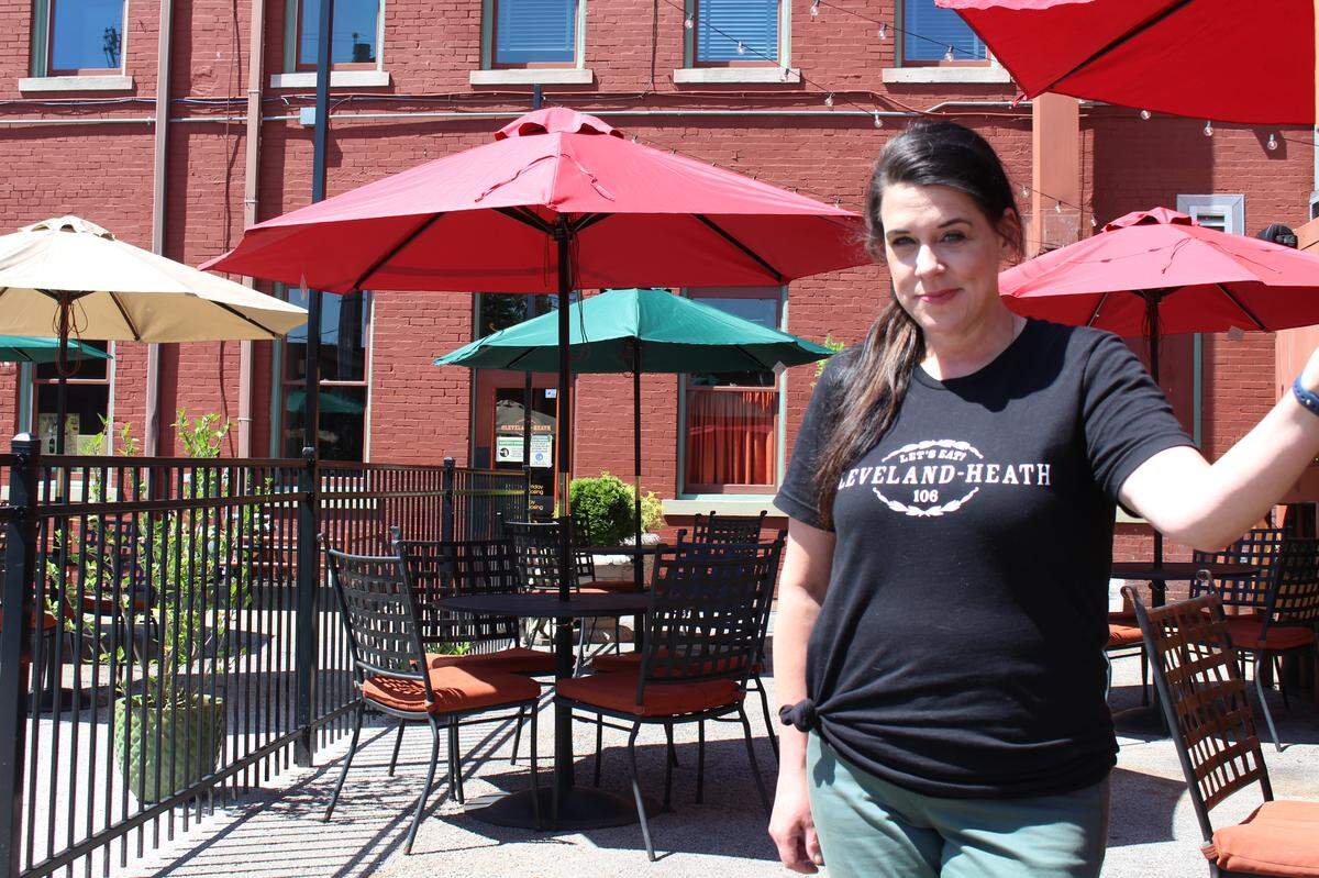 Kari McGuinness, co-owner of Cleveland Heath in Edwardsville, takes a break from preparing the restaurant and bar’s expanded patio for reopening on Friday.