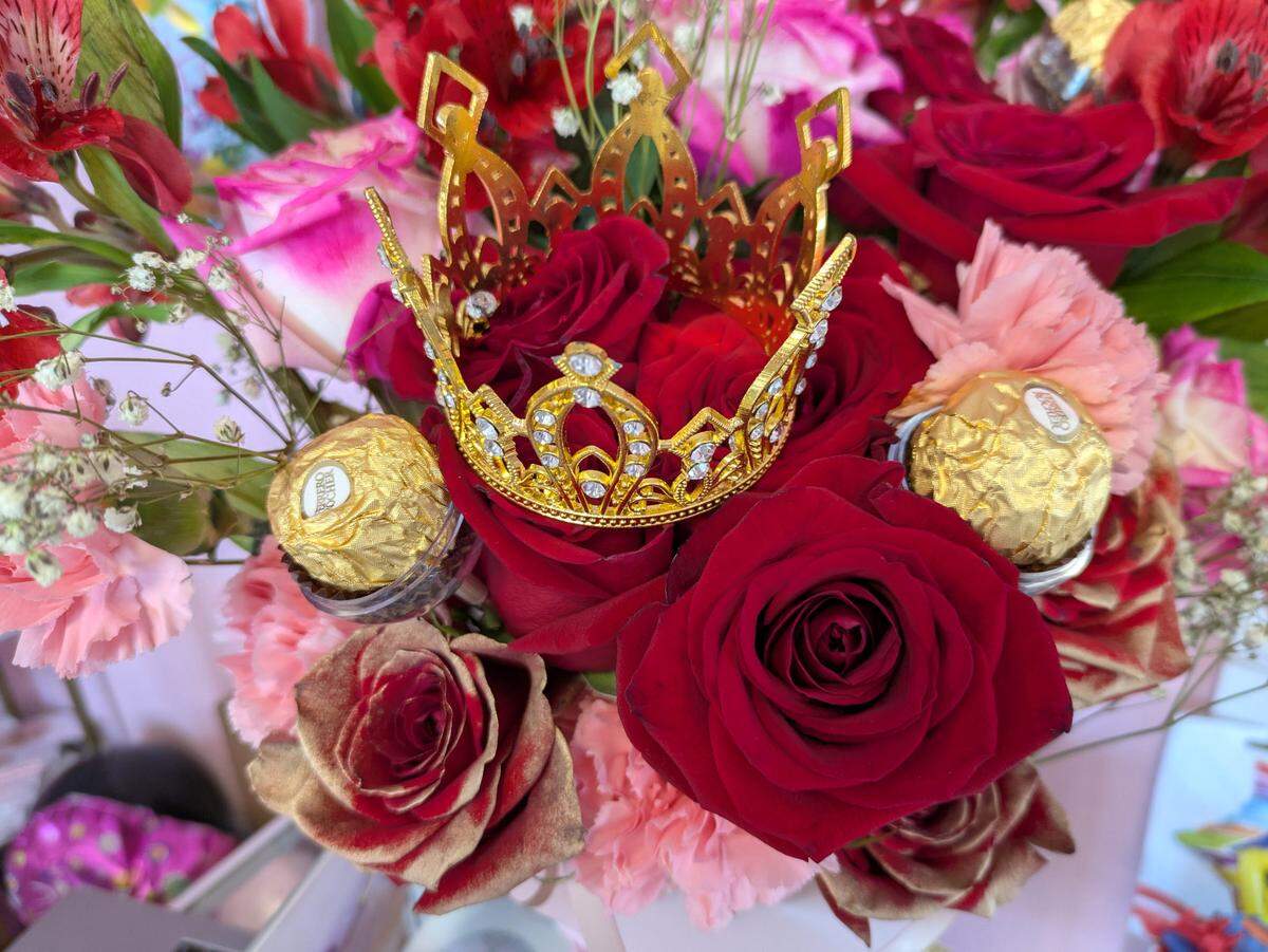 Special touches like the gold crown and chocolates in this flower bouquet show the attention and detail put into displays and decorations offered at ALCE Luxury Events/LovelyLoons.