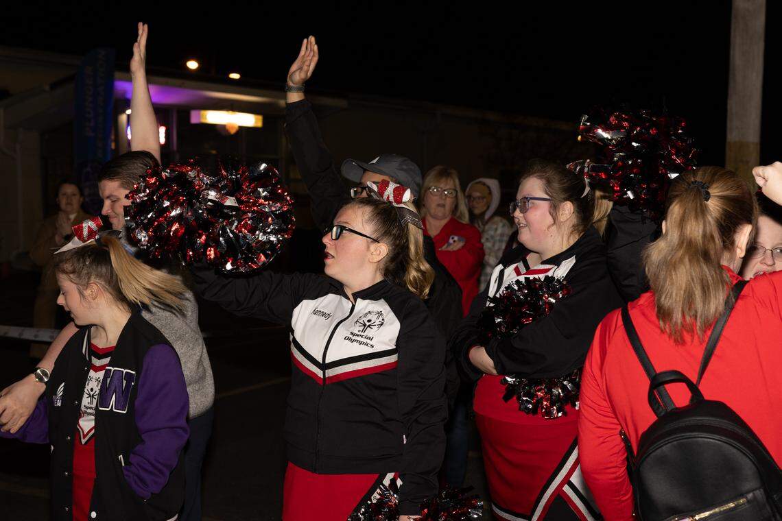 Cheerleaders with the Special Olympics Illinois wave as plungers line up to leap into a dumpster full of cold water in Collinsville Friday.