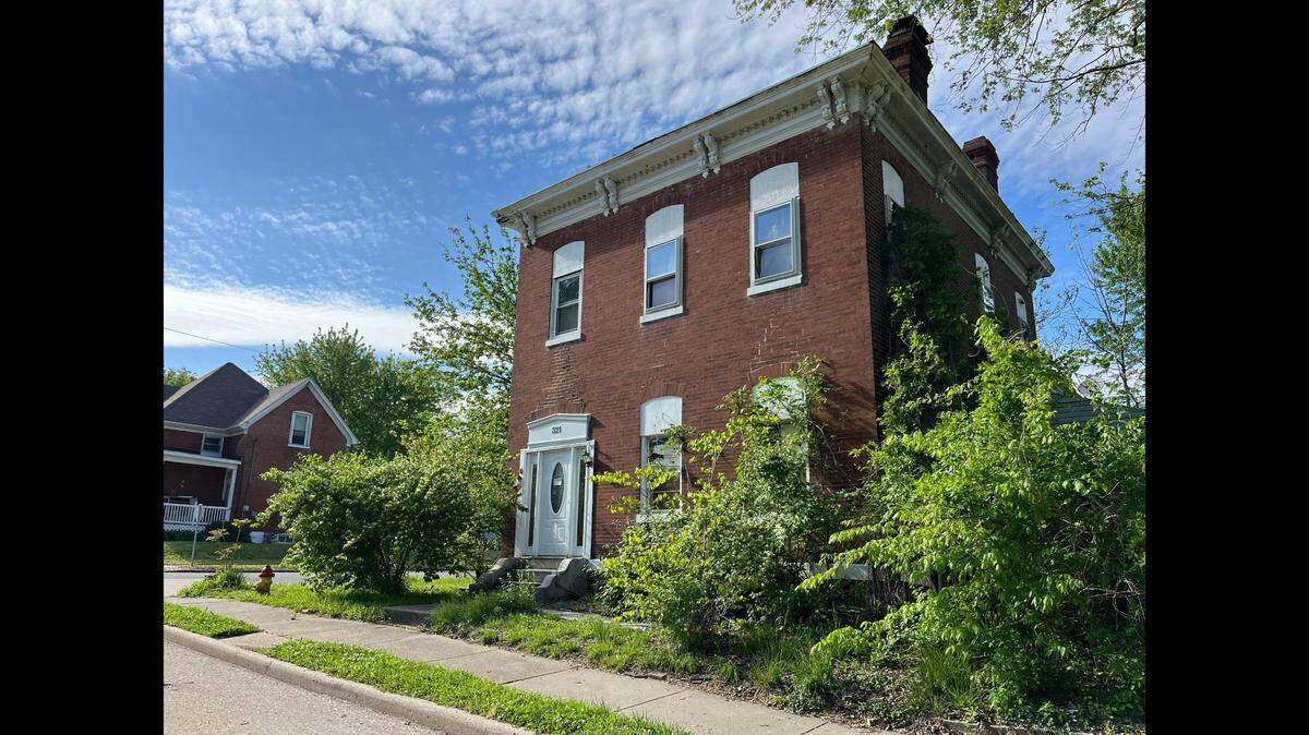 This photo taken in May 2024 shows a two-story brick home at 321 W. C St. in Belleville that is vacant, derelict and obscured by overgrown trees and bushes. It was considered a “mansion” in the late 1800s.