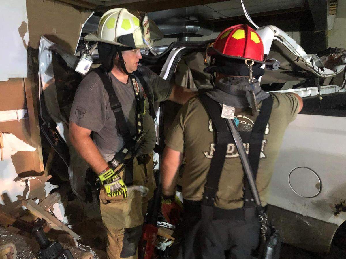 First responders worked to extricate a man trapped in a truck that crashed into a Fairview Heights home early Tuesday morning.