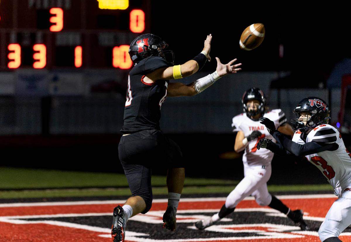 Highland Brenden Gelly catches a touchdown pass from quarterback Brent Wuebbels in the third quarter of Friday night’s Mississippi Valley Conference home game against Triad. The Bulldogs ultimately posted a 35-0 victory.
