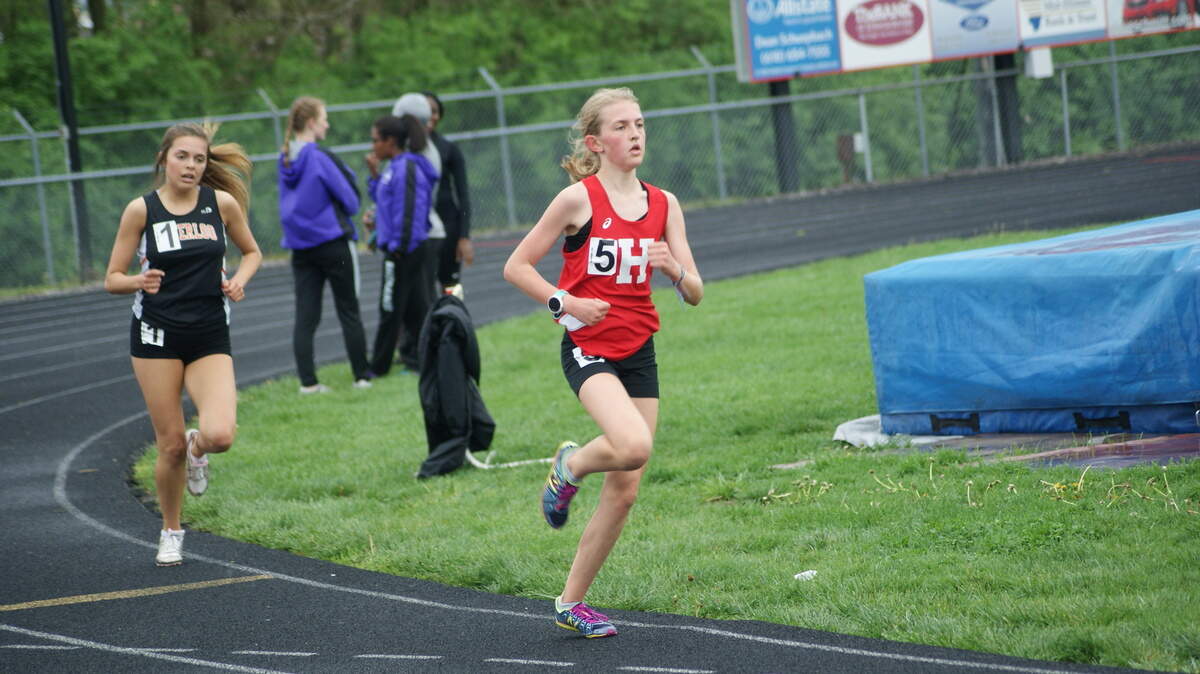 Highland freshman Grace Meyer pulls away from Waterloo junior Ella King over the last 100 meters to win the 3,200-meter run by six seconds with a winning time of 12:03 at the Mississippi Valley Conference Championships Thursday at Highland High School.