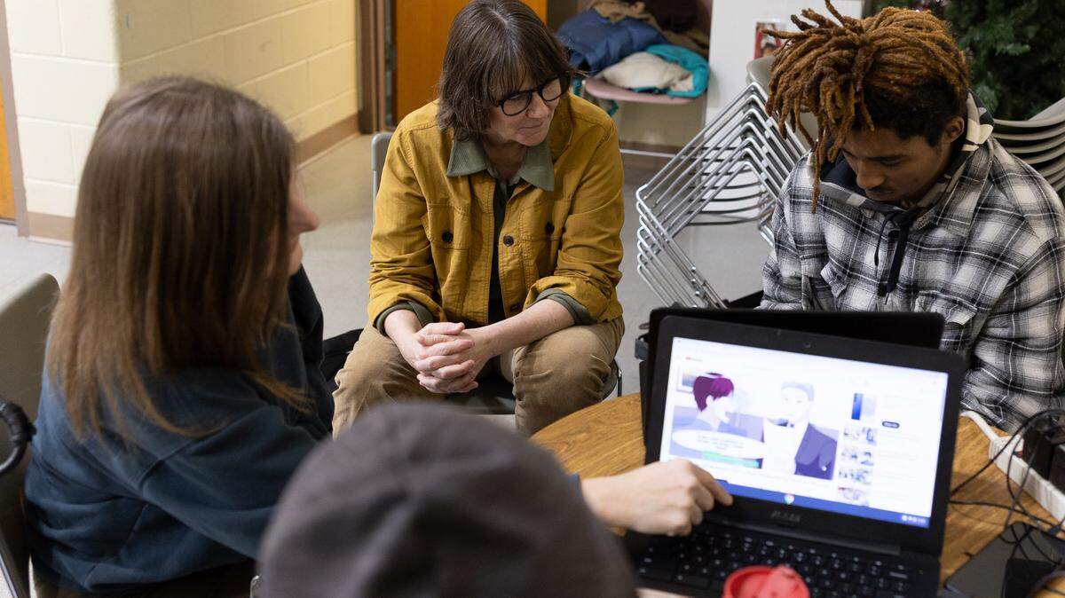 Kara Moore, left, board member and director of community development for TOCO (Tapestry of Community Offerings), and Maria Maloy, center, co-director of TOCO’s Sanctuary Drop-in program at The Salvation Army, assist youths in need with career training and resume building at The Salvation Army in Belleville on Wednesday.