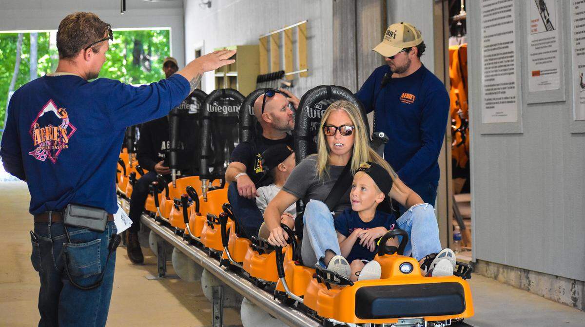A family listens to instructions given from the Aerie’s Alpine Coaster Team as they prepare the family for their first ride on the coaster during its official opening weekend.