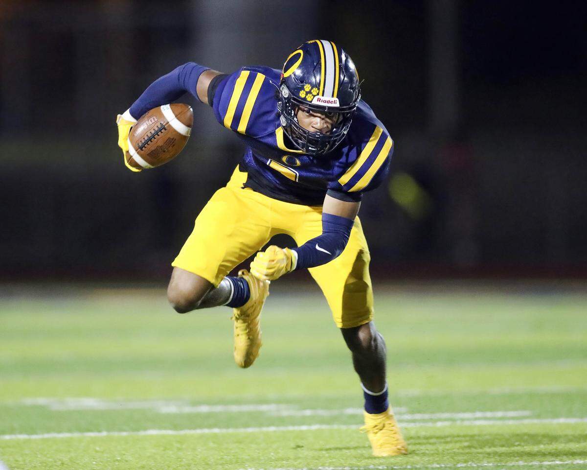 O’Fallon’s Jalen Smith carries the ball during Saturday night’s IHSA Class 8A playoff game against Edwardsville. The Tigers prevailed 43-36.