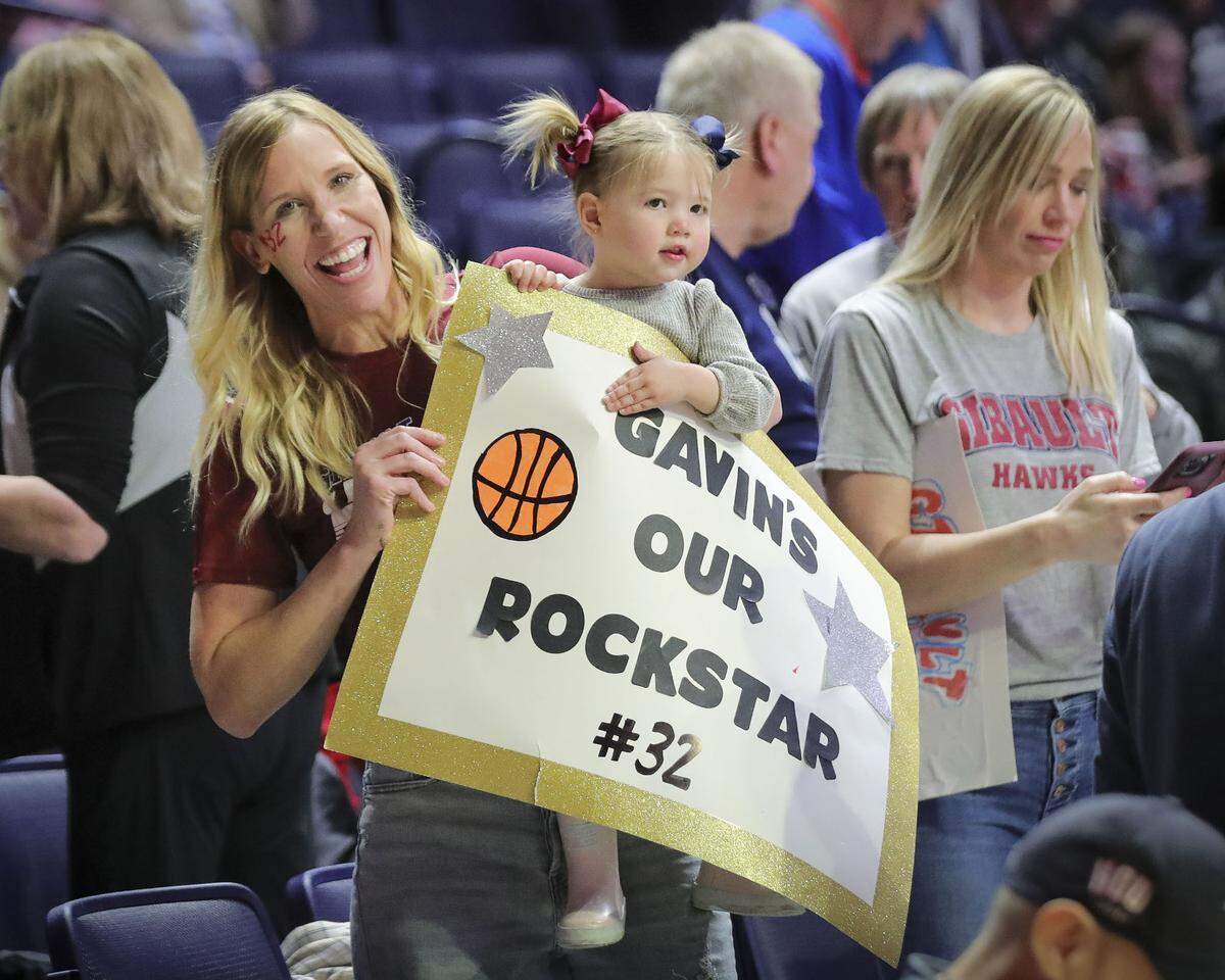 Gibault Catholic’s Gavin Kesler fans Katrina and Ruby Wright prepare for Saturday’s IHSA Class 1A state championship game against Scales Mounds at the State Farm Center on the campus of the University of Illinois. Gibault ultimately prevailed 65-45 to claim the state title. A parade/celebration to honor the team is set for Sunday.