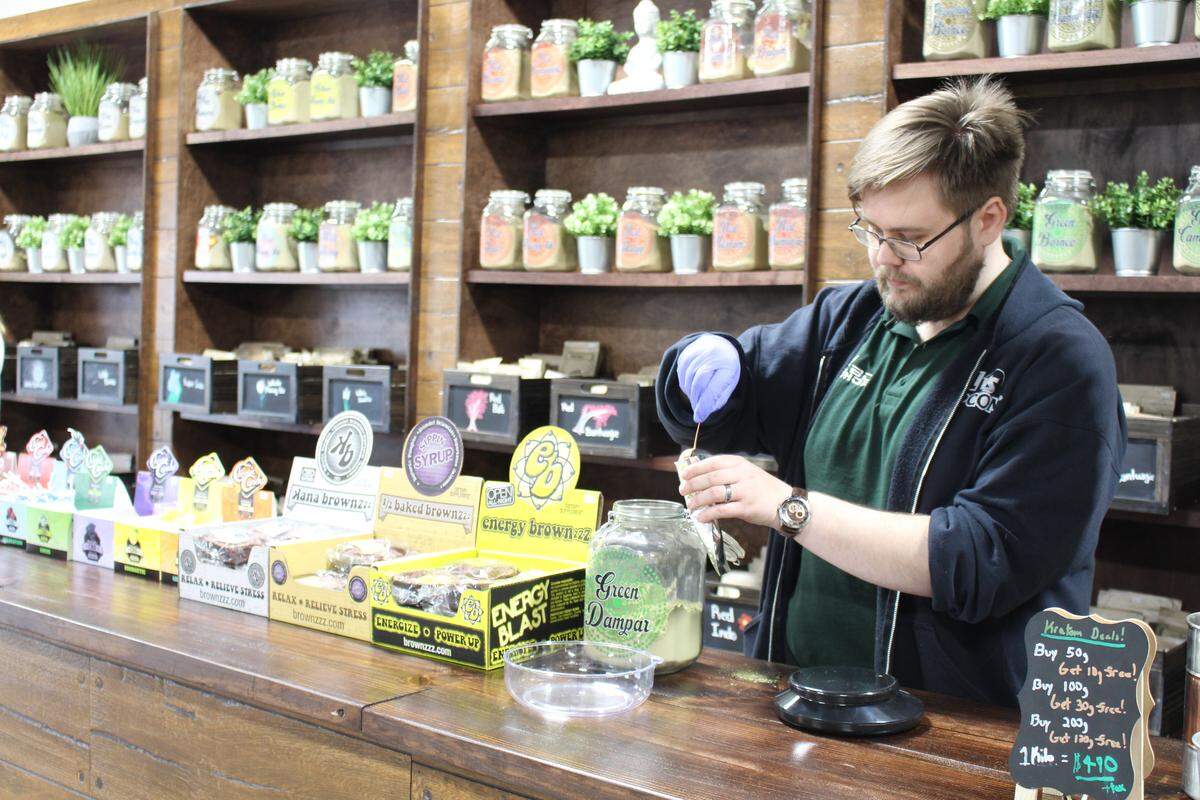 Employee Marty Schulz fills a bag with “green dampar” kratom powder at the CBD Kratom store in Belleville in this 2019 photo.