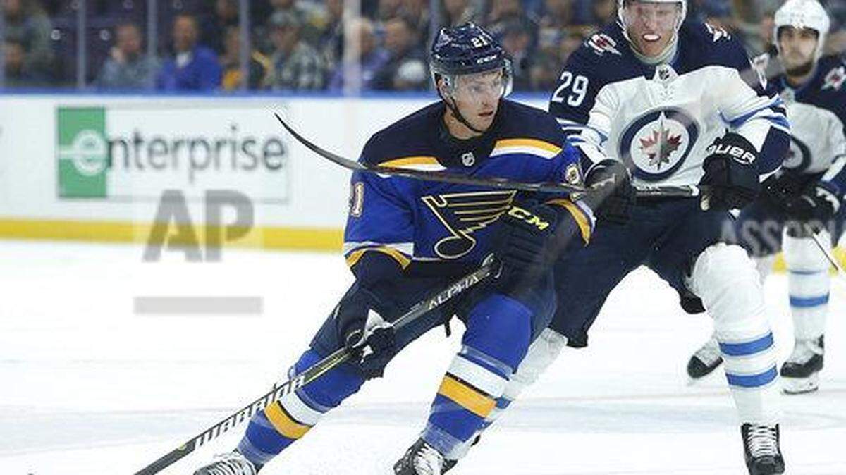 St. Louis Blues center Tyler Bozak (21) and Winnipeg Jets right wing Patrik Laine (29), of Finland, vie for control of the puck during the first period of an NHL hockey game Thursday, Oct. 4, 2018, in St. Louis.