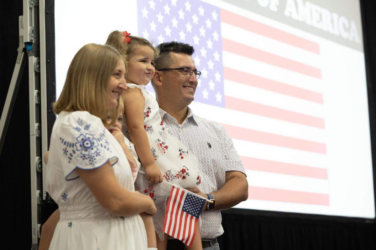 Andrei Marinho, who immigrated from Brazil, stands by his family prior to a naturalization ceremony in Collinsville.