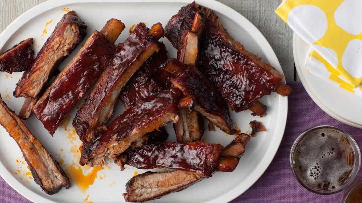 Precooking ribs in the oven, then finishing them off on the grill, is an easy way to get food ready for a Memorial Day weekend party.