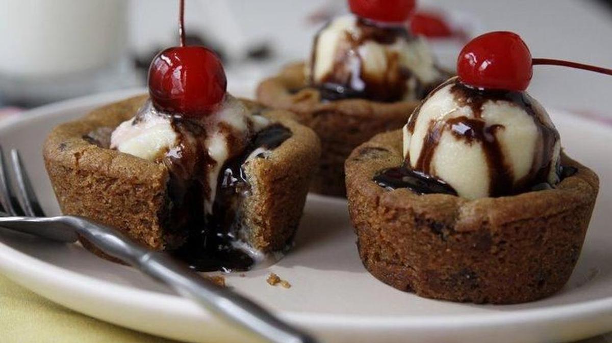 Fill easy cookie cups with ice cream, syrup.