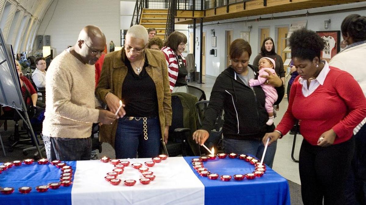 Participants in the Annual World AIDS Day event at Bethany Place light candles in remembrance of friends and family living with or those who have died because of AIDS.