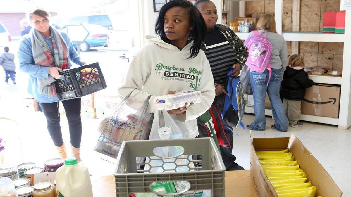 Brandi Wright and other parents pick up items inside the Lighthouse Learning Center’s Little Light Food Pantry. Wright's 3-year-old son attends Lighthouse Learning Center.