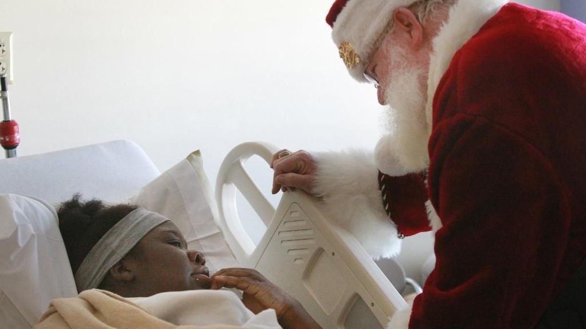 Santa Claus talks with SSM Cardinal Glennon Children’s Medical Center patient during Fire Truck O’ Toys event.