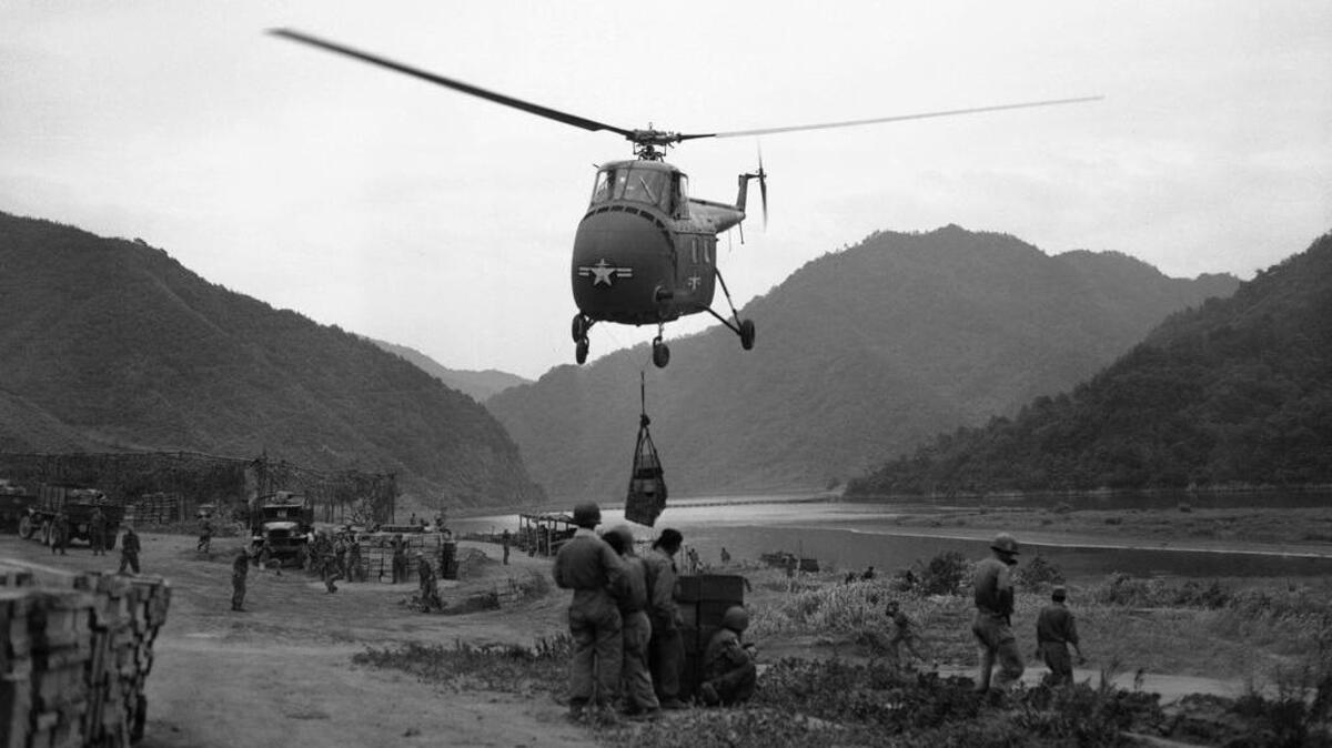 The helicopter picks up the supplies and takes off with its load for the ROK troops on the north side of the Pukhan River on June 20, 1953 in South Korea.