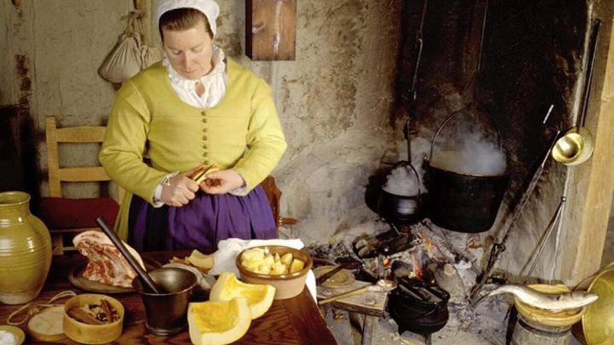 A colonial English woman prepares pompion (pumpkin) by the fireside at the Plimoth Plantation in Plymouth, Mass. The pumpkin would have been stewed. It was a staple, along with squash, of the Pilgrims and the Wampanoag tribe, and likely would have part of the Thanksgiving feast for 150 at the settlement in 1621.