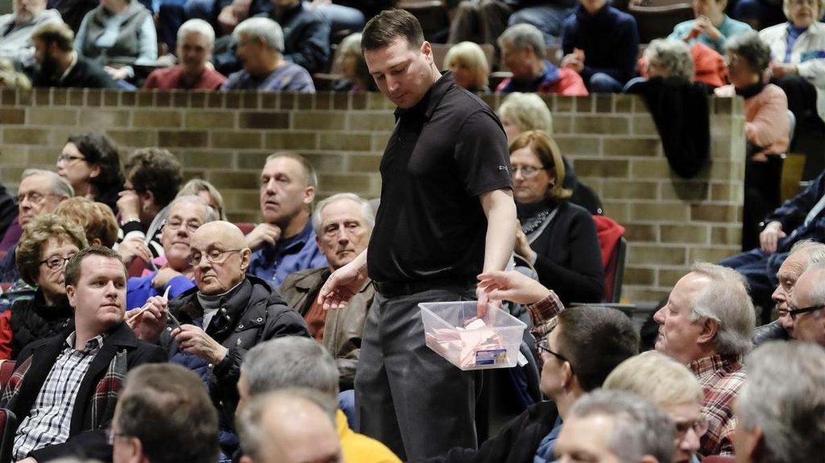Ben Uhl collects ballots during the Woodbury County Republican Precinct 28 caucus at East High School in Sioux City, Iowa, on Feb. 1, 2016.