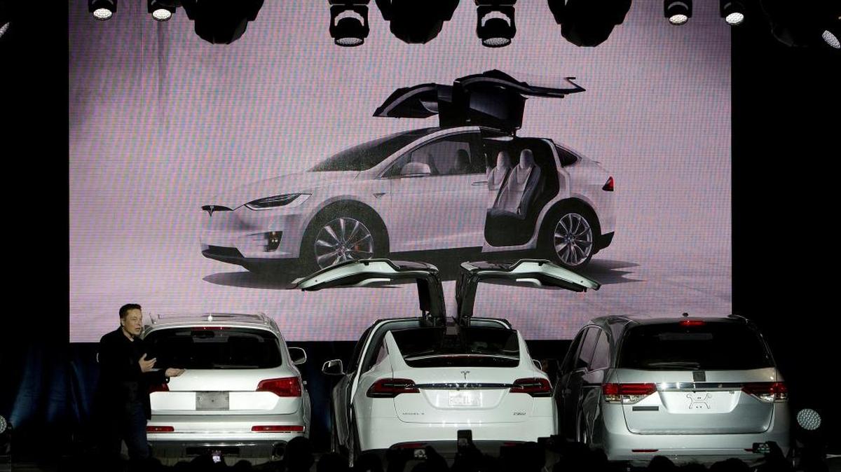 Tesla CEO Elon Musk demonstrates the space-saving benefit of the falcon wing doors of the new Model X SUV crossover on Tuesday, Sept. 29, 2015. Musk took over Tesla when Martin Eberhard was ousted.