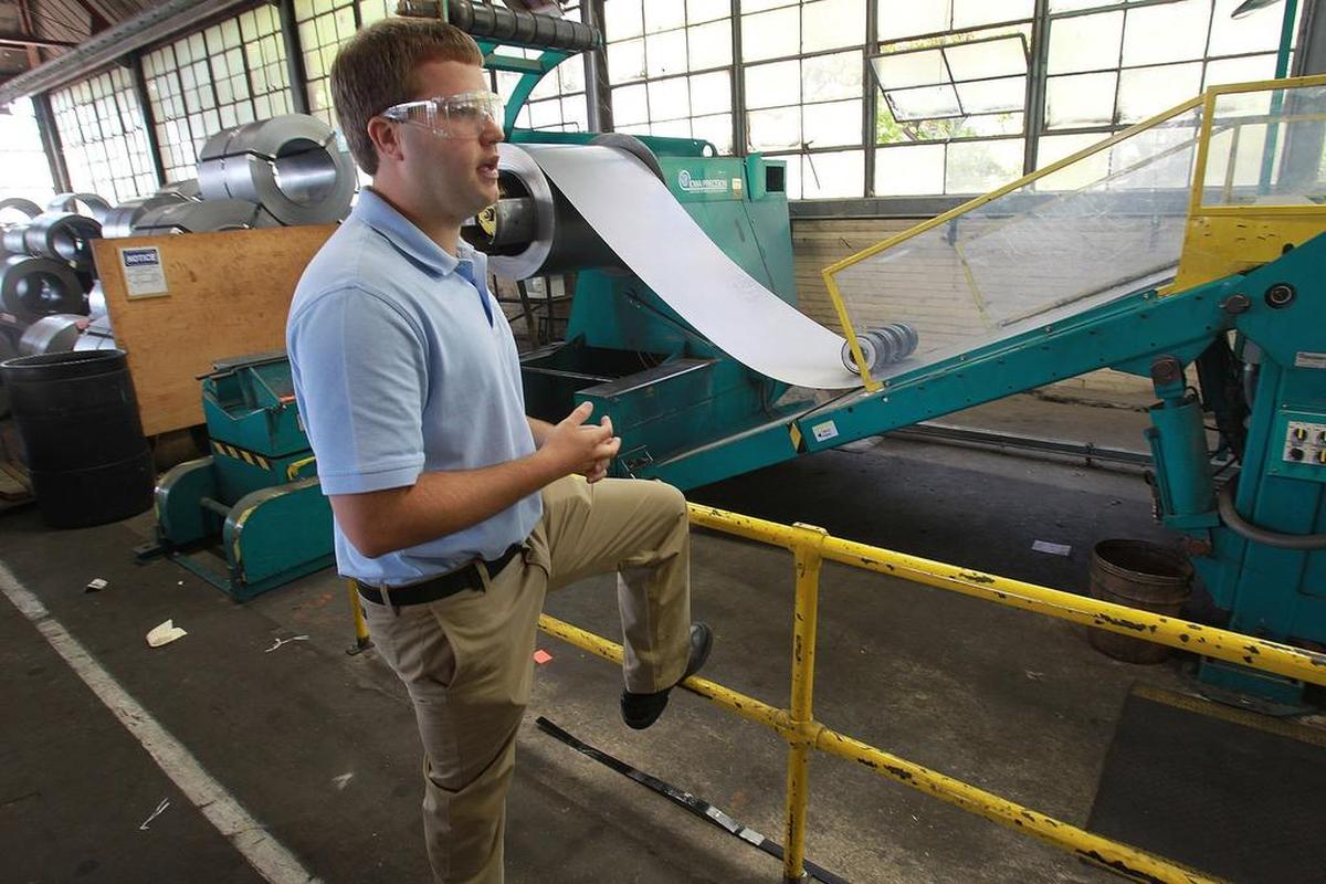 This 2017 file photo shows Nick Bauer, president of Empire Comfort Systems in Belleville, talking about a shear machine that cuts huge rolls of sheet metal to length for manufacturing gas heaters.