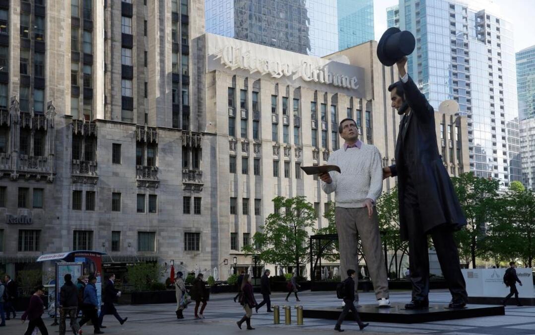In this Monday, May 1, 2017 photo, Chicago’s landmark building, Tribune Tower is seen behind a larger version of American realist Seward Johnson’s “Return Visit” sculpture in downtown Chicago. The 25-foot-tall Abraham Lincoln sculpture, right, stands next to another large-scale figure that represents a common man holding a copy of the Gettysburg Address.