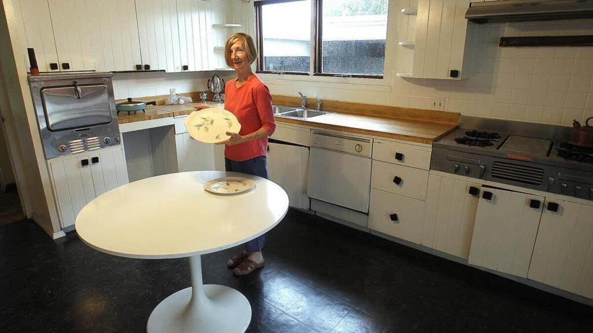 Adviser Margaret Meyer places vintage dinnerware in the kitchen of a Belleville building that’s being converted into a Mid-century Modern Architecture Museum. Its architect, Charles E. King, also designed her home in Signal Hill.